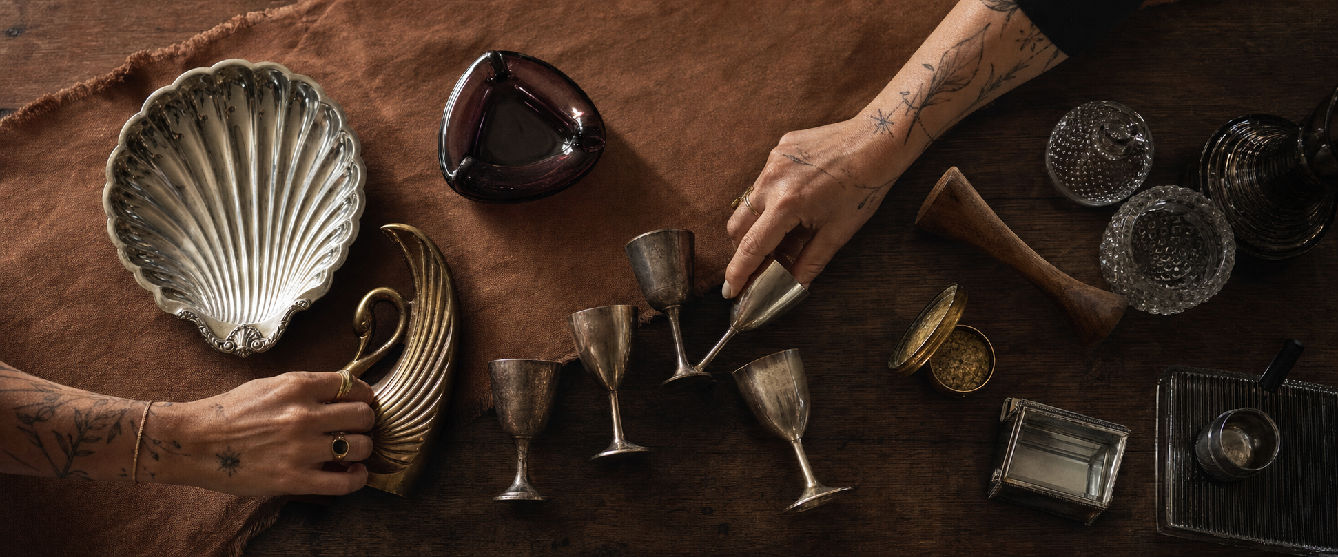 Les mains tatouées de Stéfani composant une sélection généreuse d’objets anciens